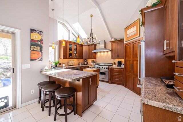 2406 Woodland Dr, Ogden, UT 84403 - kitchen featuring high end range, wall chimney exhaust hood, a kitchen bar, a peninsula, and a chandelier