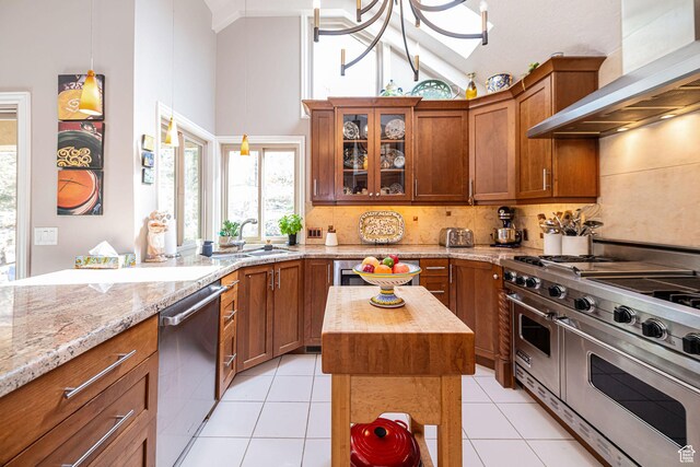 2406 Woodland Dr, Ogden, UT 84403 - kitchen featuring tasteful backsplash, light tile patterned floors, wall chimney exhaust hood, stainless steel appliances, and a sink