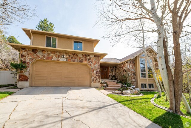 2406 Woodland Dr, Ogden, UT 84403 - view of front facade with stone siding, a garage, driveway, and stucco siding