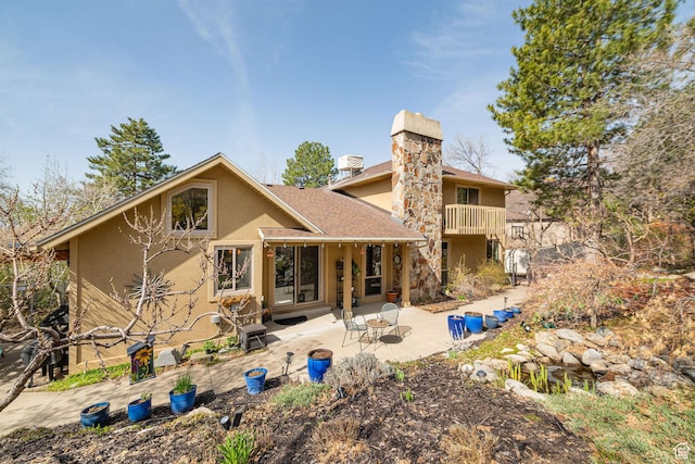 2406 Woodland Dr, Ogden, UT 84403 - rear view of property featuring a patio area, a balcony, stucco siding, and a chimney