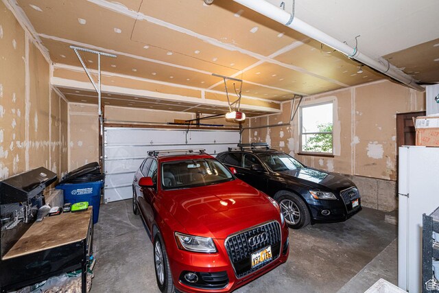 2406 Woodland Dr, Ogden, UT 84403 - garage featuring freestanding refrigerator and a garage door opener