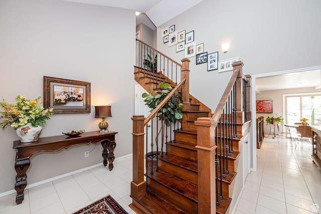 2406 Woodland Dr, Ogden, UT 84403 - staircase featuring tile patterned floors, high vaulted ceiling, and baseboards