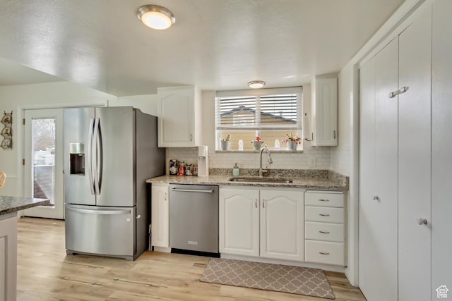 1224 S 760 W, Provo, UT 84601 - kitchen with tasteful backsplash, white cabinets, a sink, light wood finished floors, and stainless steel appliances