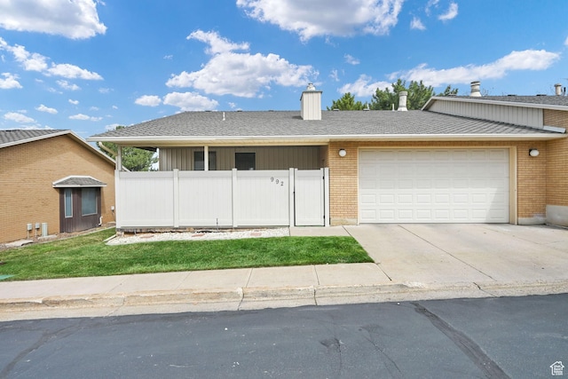 view of front of house featuring an attached garage, a chimney, fence, concrete driveway, and brick siding