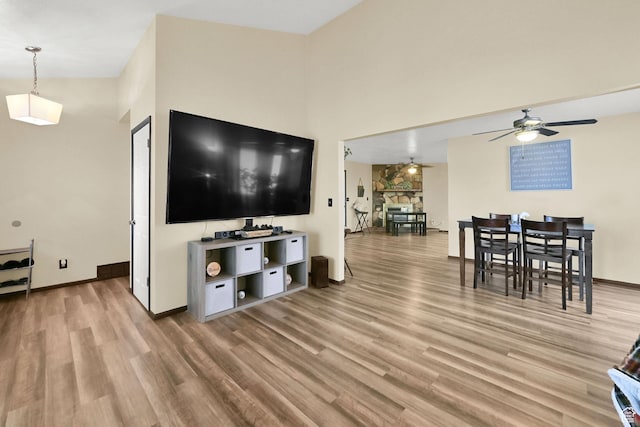 992 E 5625 S, South Ogden, UT 84405 - living room featuring light wood finished floors, a towering ceiling, baseboards, and a ceiling fan