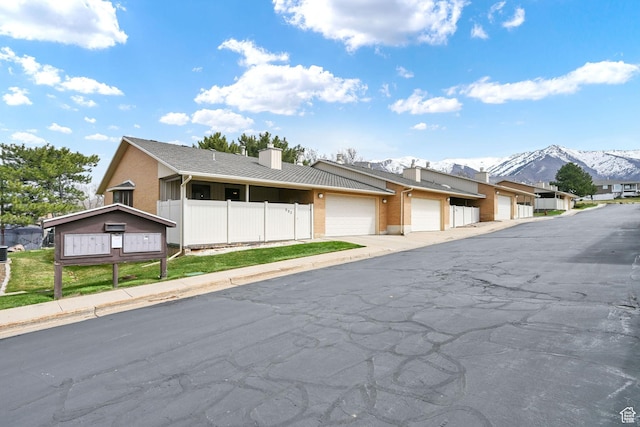 992 E 5625 S, South Ogden, UT 84405 - view of front facade featuring fence, brick siding, a mountain view, and a chimney