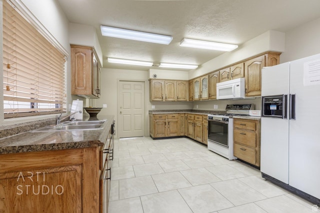 145 S Crystal Lakes Dr Unit 80, St George, UT 84770 - kitchen with white appliances, dark countertops, a textured ceiling, and light tile patterned flooring