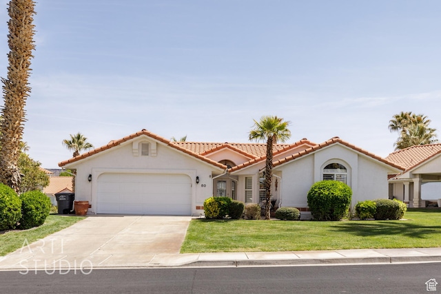 mediterranean / spanish home featuring stucco siding, a front yard, a tile roof, a garage, and concrete driveway