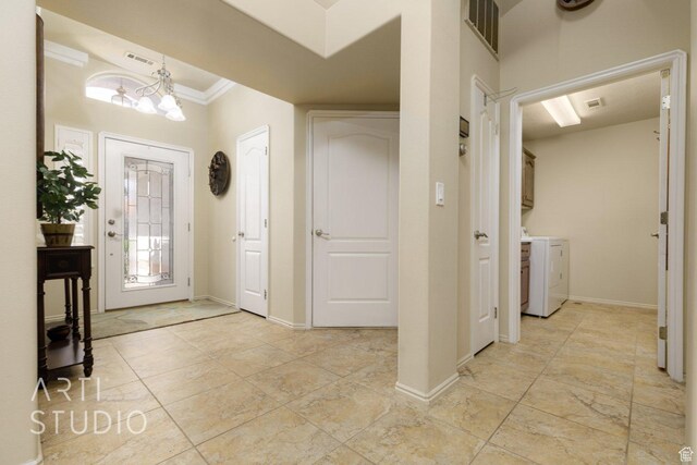 145 S Crystal Lakes Dr Unit 80, St George, UT 84770 - foyer with washing machine and dryer, crown molding, and a chandelier