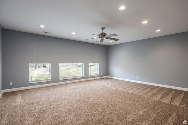 spare room featuring carpet, ceiling fan, baseboards, plenty of natural light, and recessed lighting