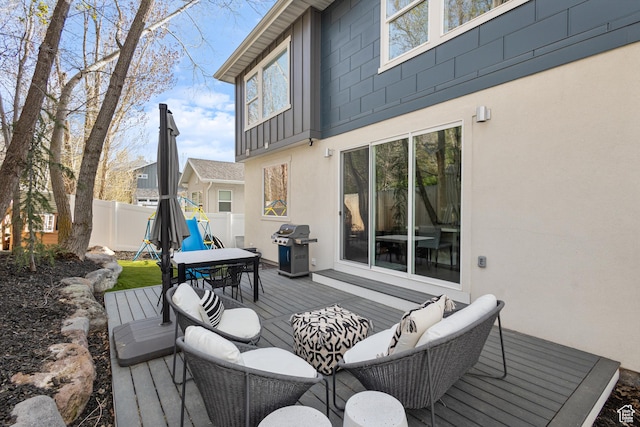 wooden terrace featuring grilling area, an outdoor hangout area, and fence