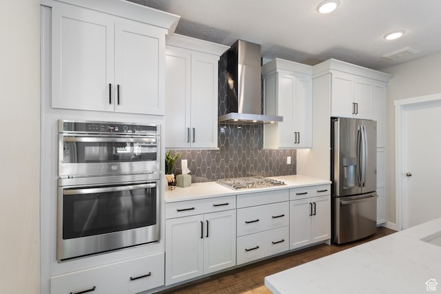 11779 S Windcroft Ct E, Sandy, UT 84092 - kitchen with stainless steel appliances, wall chimney exhaust hood, backsplash, white cabinets, and dark wood-style flooring