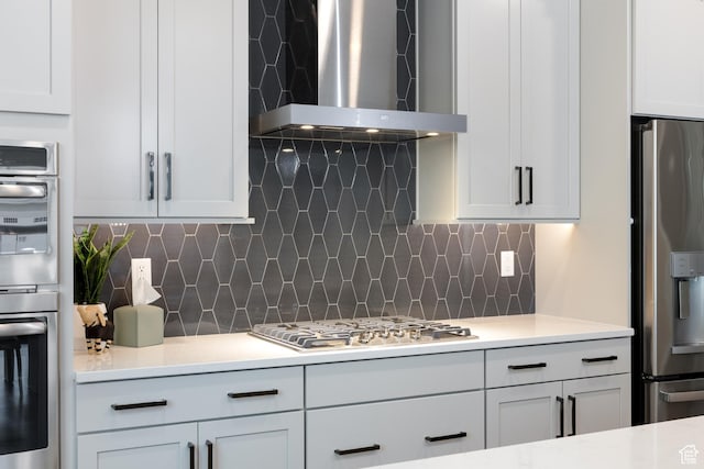 11779 S Windcroft Ct E, Sandy, UT 84092 - kitchen featuring stainless steel appliances, wall chimney range hood, light countertops, tasteful backsplash, and white cabinets