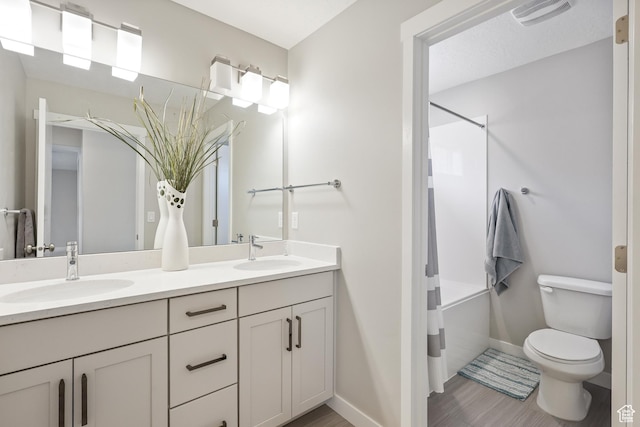 full bath with double vanity, visible vents, a sink, and toilet