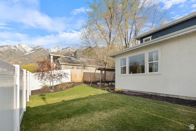 view of yard featuring a mountain view and a fenced backyard