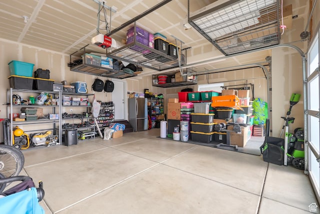 garage with freestanding refrigerator and a garage door opener