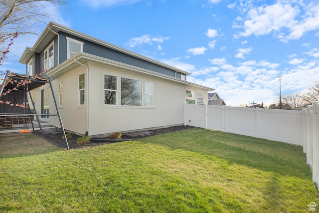 rear view of property with a yard and a fenced backyard