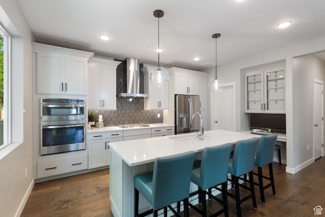 11779 S Windcroft Ct E, Sandy, UT 84092 - kitchen featuring wall chimney exhaust hood, stainless steel appliances, backsplash, a breakfast bar, and recessed lighting