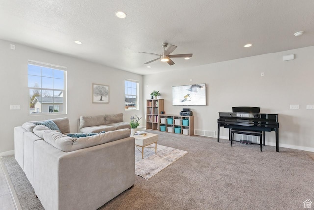 carpeted living room featuring baseboards, recessed lighting, a textured ceiling, and a ceiling fan