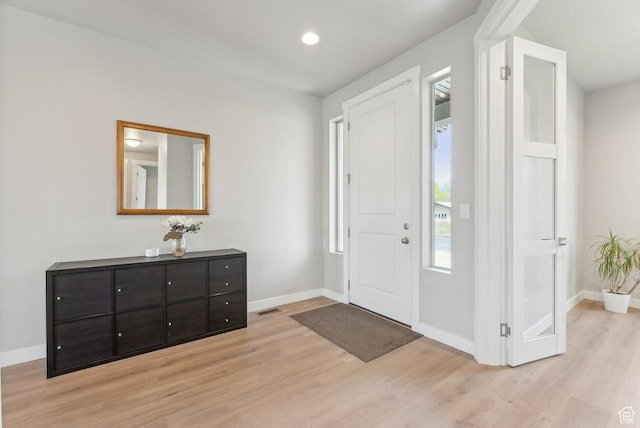 entryway with light wood finished floors and baseboards