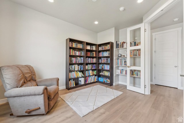 living area with recessed lighting, baseboards, and wood finished floors