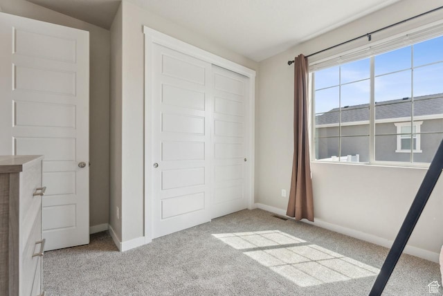 unfurnished bedroom featuring carpet, a closet, and baseboards