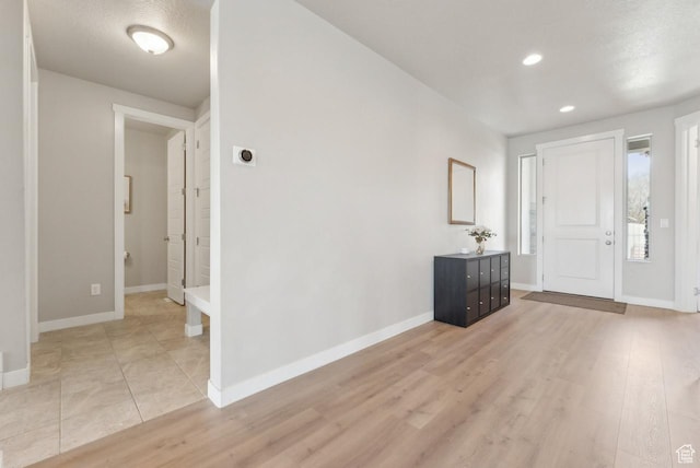 entryway featuring baseboards and light wood finished floors