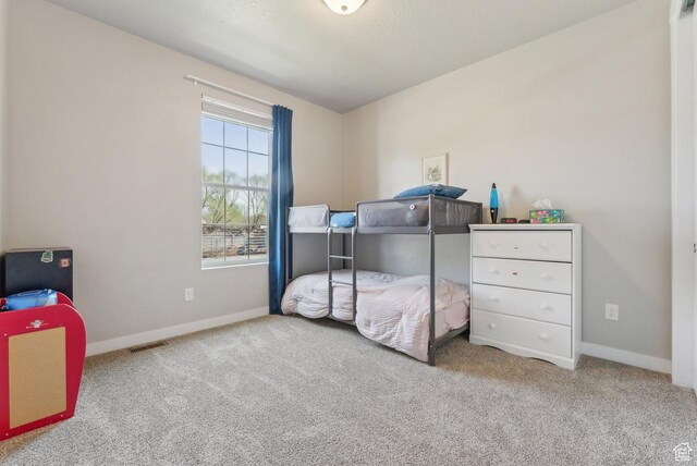 bedroom with carpet, visible vents, and baseboards