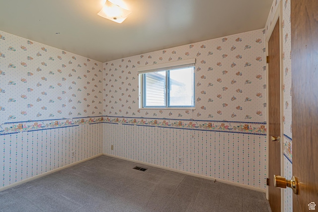 unfurnished room with wallpapered walls, carpet flooring, baseboards, and visible vents
