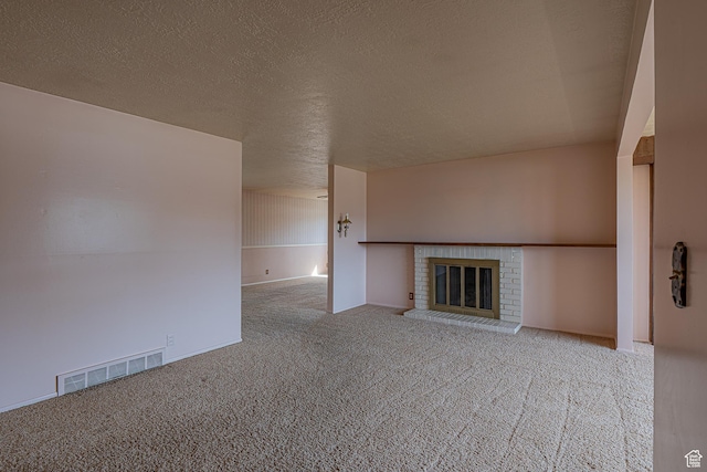 unfurnished living room featuring a fireplace, carpet, visible vents, and a textured ceiling