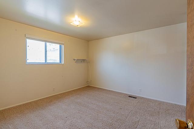 carpeted empty room featuring visible vents and baseboards