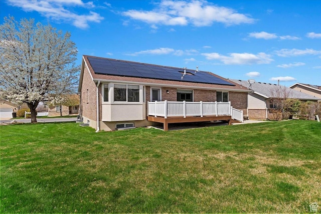 32 Belmore Dr, Kaysville, UT 84037 - back of property with brick siding, a deck, a lawn, and roof mounted solar panels