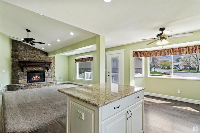 32 Belmore Dr, Kaysville, UT 84037 - kitchen with light stone counters, a fireplace, ceiling fan, lofted ceiling, and wood finished floors