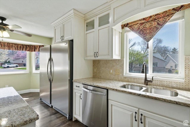 32 Belmore Dr, Kaysville, UT 84037 - kitchen with dark wood-style flooring, light stone countertops, decorative backsplash, stainless steel appliances, and a sink