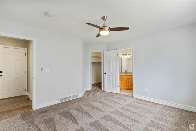 32 Belmore Dr, Kaysville, UT 84037 - unfurnished bedroom featuring a walk in closet, light carpet, baseboards, and visible vents