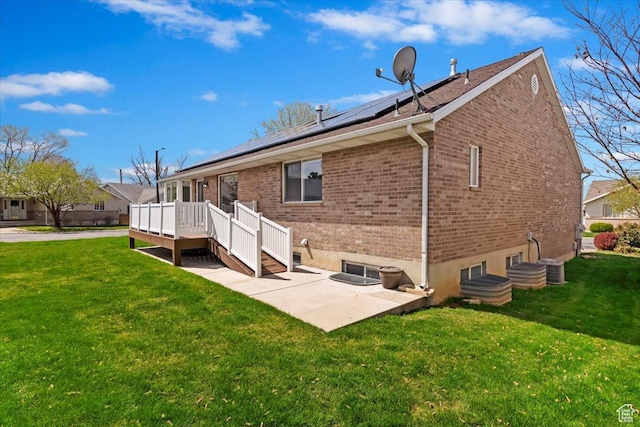 32 Belmore Dr, Kaysville, UT 84037 - back of house with a patio area, brick siding, solar panels, a yard, and a deck