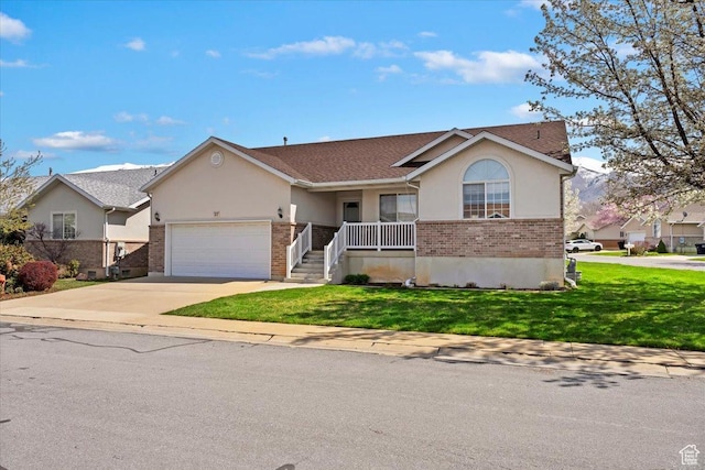 single story home with a front yard, an attached garage, stucco siding, brick siding, and driveway
