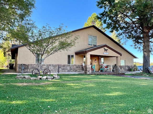 back of property featuring a yard, stucco siding, and stone siding