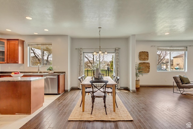 dining area with light wood-style flooring, an inviting chandelier, and a healthy amount of sunlight