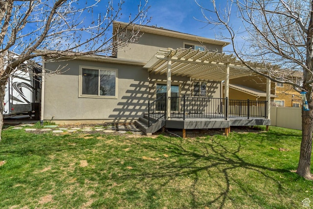 back of house with a pergola, stucco siding, a lawn, fence, and a deck