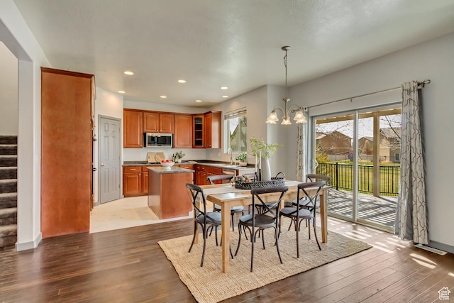 dining area with wood finished floors, an inviting chandelier, recessed lighting, and stairway