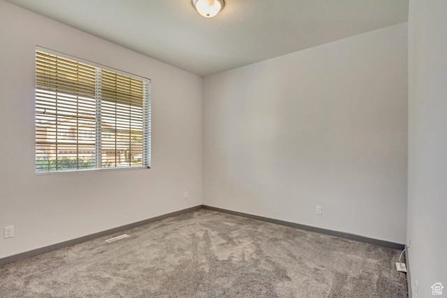 empty room with baseboards and carpet