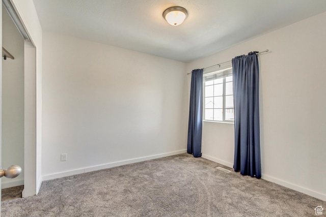 carpeted empty room with visible vents and baseboards