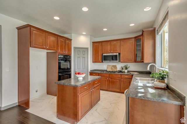 kitchen featuring a center island, a sink, dark countertops, appliances with stainless steel finishes, and marble finish floor