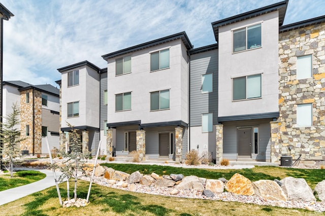 view of front facade featuring stucco siding and stone siding