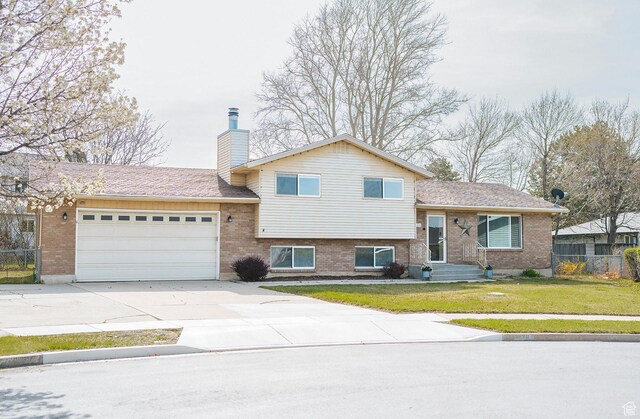 20 E 9n Cir N, American Fork, UT 84003 - tri-level home featuring a front yard, fence, brick siding, a chimney, and a garage