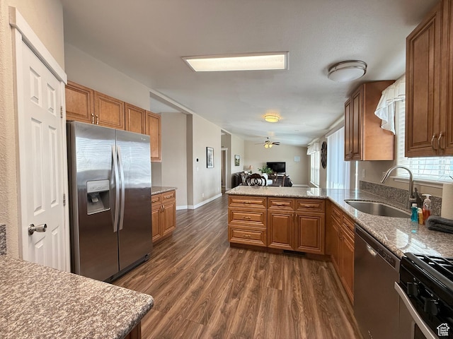 288 W Stuart Dr, Garden City, UT 84028 - kitchen with a sink, dark wood-style flooring, a peninsula, brown cabinets, and stainless steel appliances