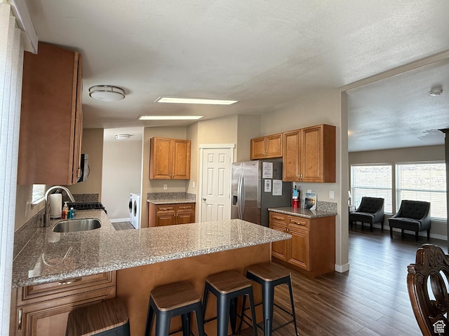 288 W Stuart Dr, Garden City, UT 84028 - kitchen featuring stainless steel fridge with ice dispenser, a peninsula, dark wood-style floors, washer and dryer, and a sink