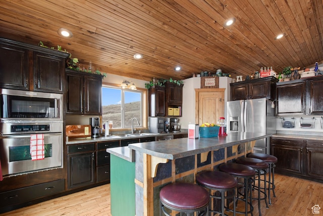 671 W Dee Dr, Garden City, UT 84028 - kitchen featuring stainless steel appliances, a kitchen breakfast bar, a center island, and dark brown cabinets