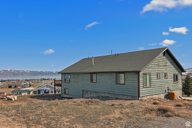 671 W Dee Dr, Garden City, UT 84028 - view of side of home featuring a shingled roof and a water view